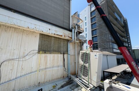 ④室外機をユニックで上げながら屋根葺き